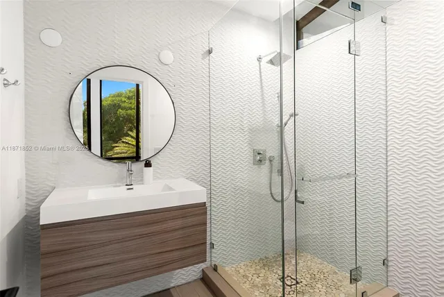 a bathroom with a sink mirror and shower