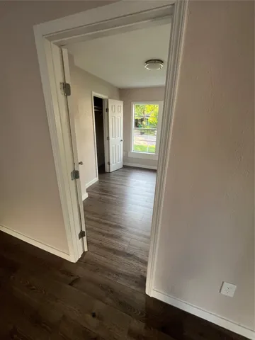 a view of a hallway with wooden floor and stairs