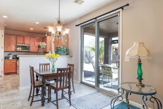 a dining room filled chandelier and wooden floor
