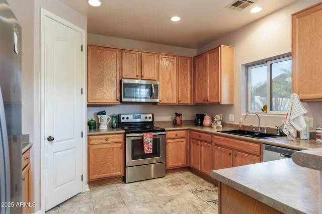 a kitchen with stainless steel appliances granite countertop a sink a stove and a microwave