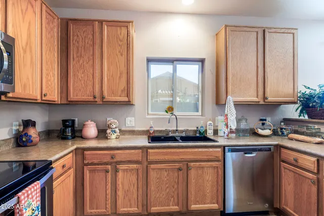 a kitchen with stainless steel appliances granite countertop a sink a stove cabinets and a refrigerator