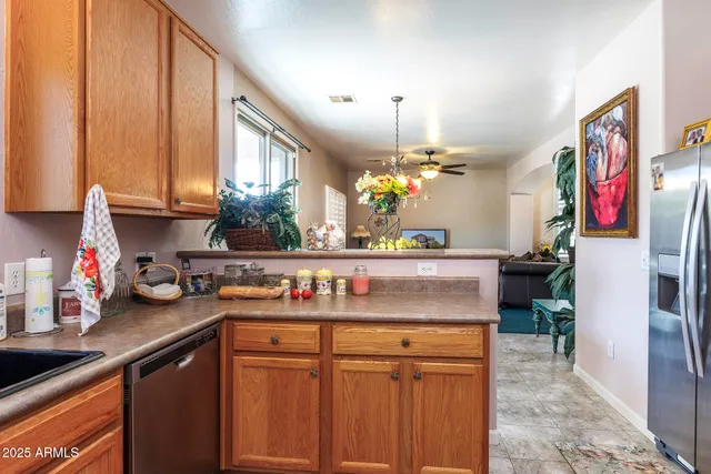 a kitchen with stainless steel appliances granite countertop a sink a stove cabinets and a dining table