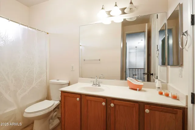 a bathroom with a sink vanity mirror and toilet