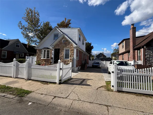 a view of a house with a small yard and wooden fence