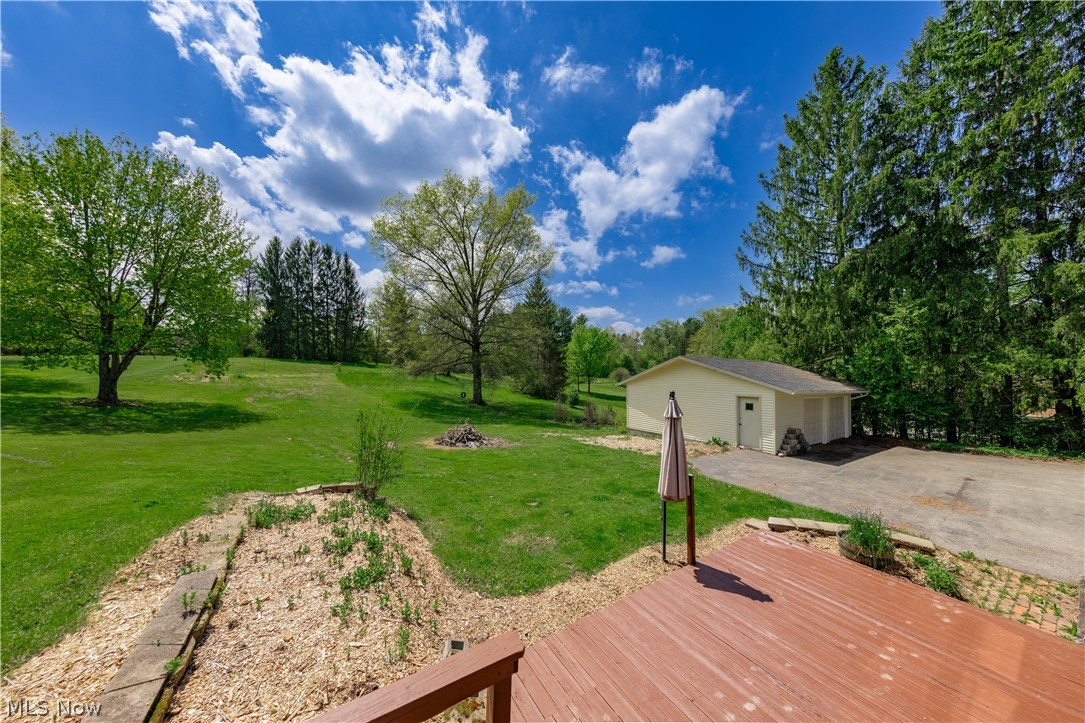 7969 Dines Road Novelty, OH 44072 - Photo 46 of 48 Beautiful backyard with green lawn with mature trees, featuring a large detached two-car garage and a wood deck