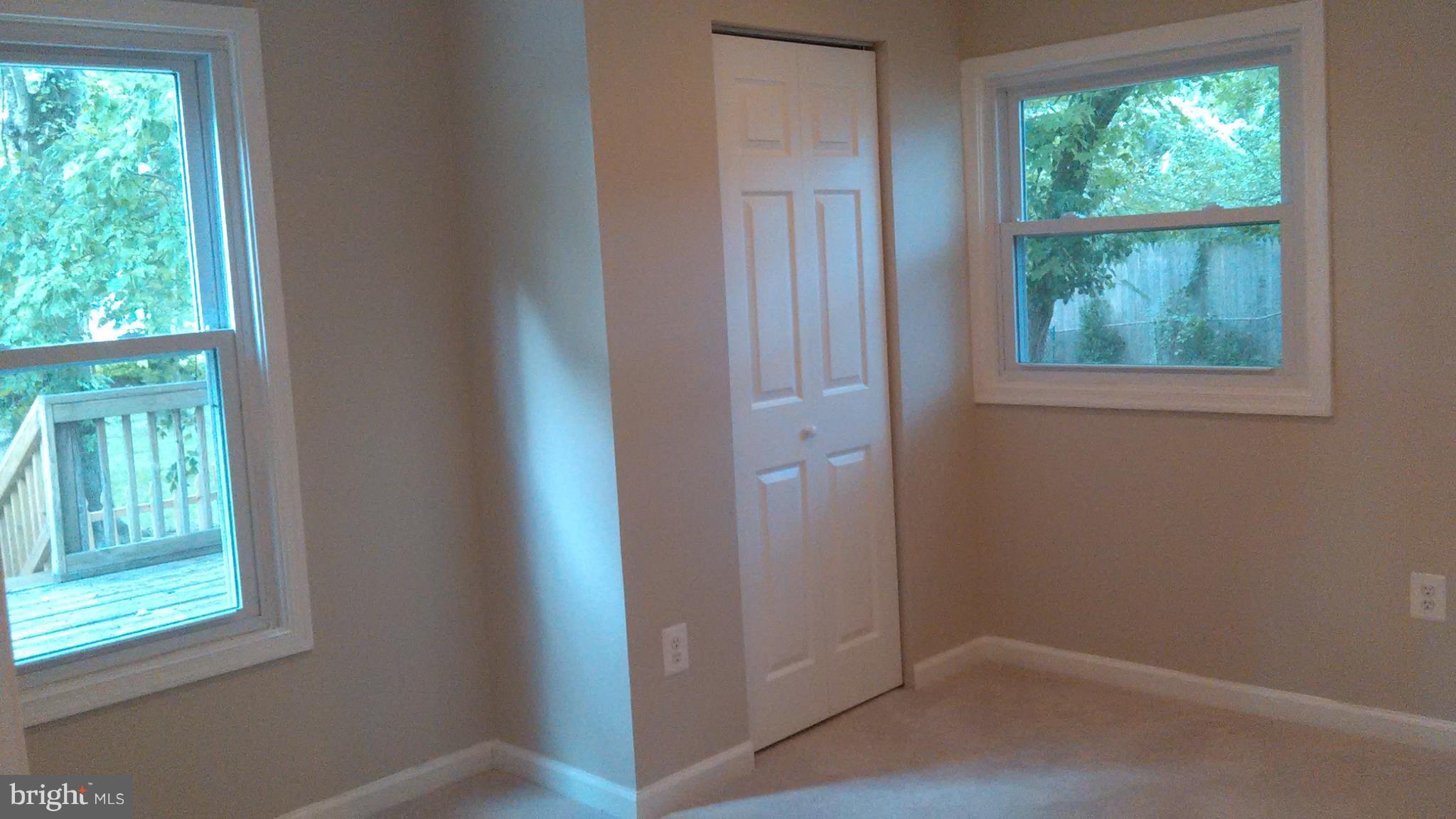 7701 Greenleaf Road Landover, MD 20785 - Photo 12 of 24 an empty room with wooden floor and windows
