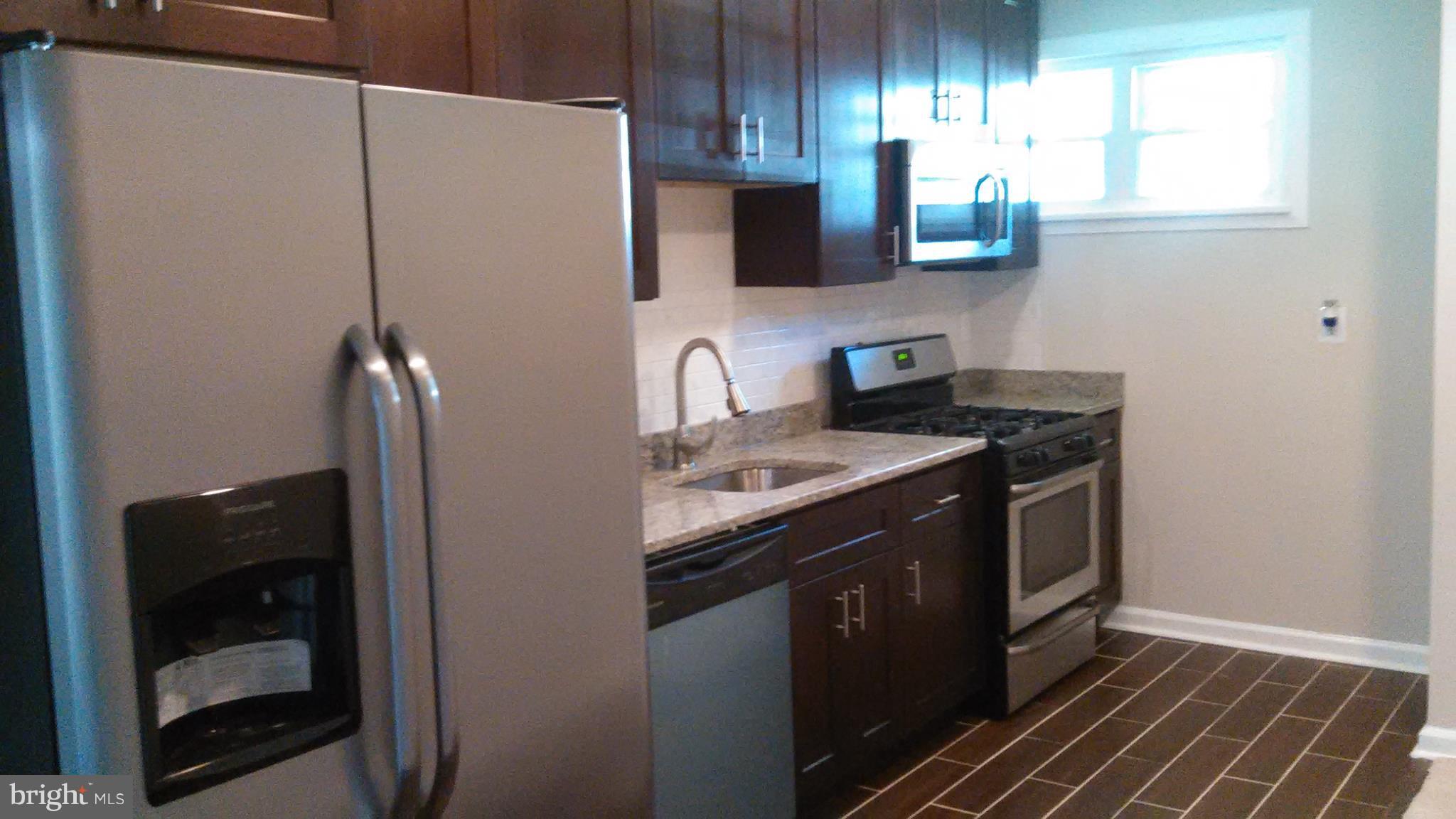 7701 Greenleaf Road Landover, MD 20785 - Photo 6 of 24 a kitchen with stainless steel appliances granite countertop a sink stove and refrigerator