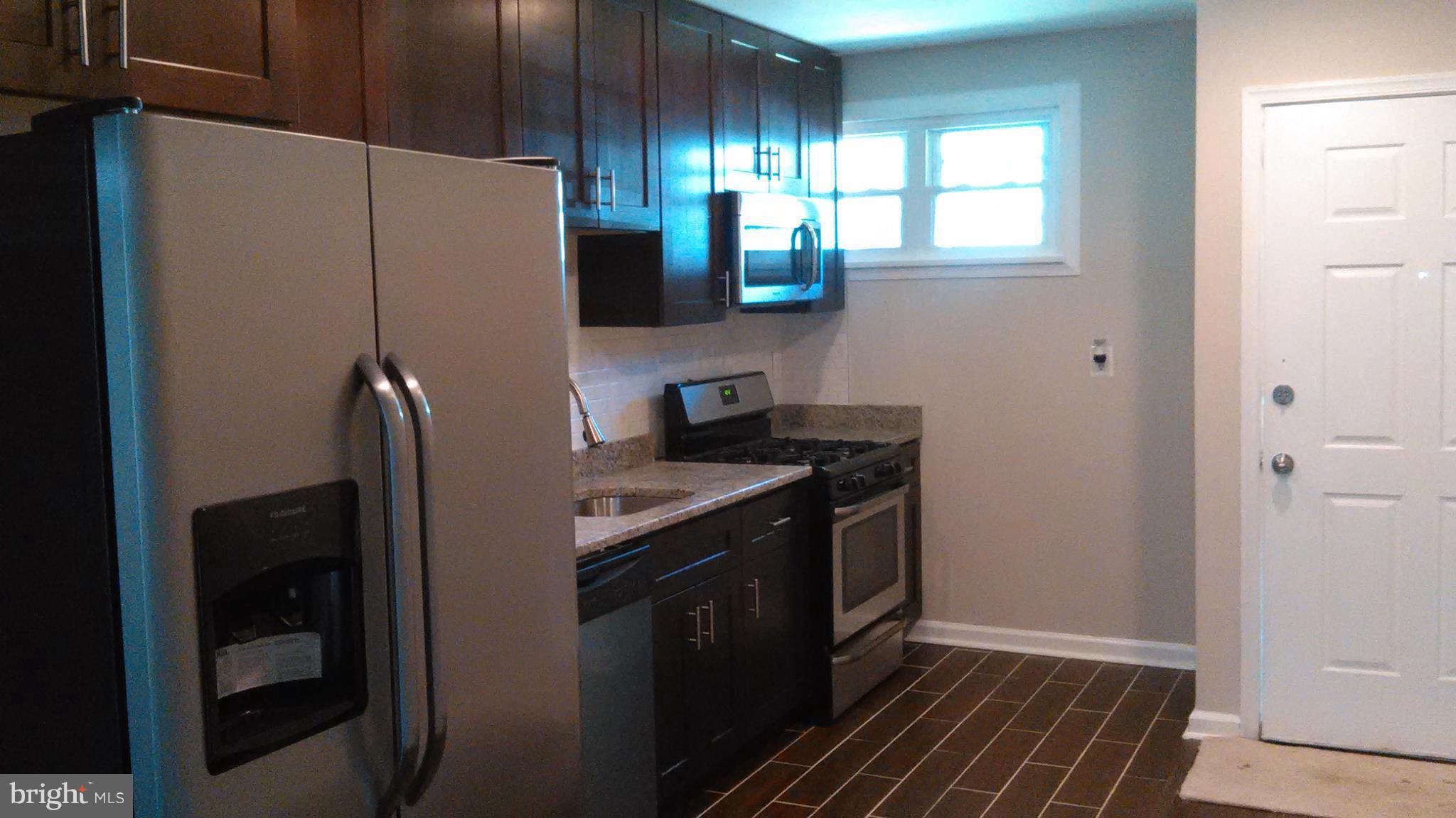 7701 Greenleaf Road Landover, MD 20785 - Photo 8 of 24 a kitchen with stainless steel appliances granite countertop a refrigerator and a sink