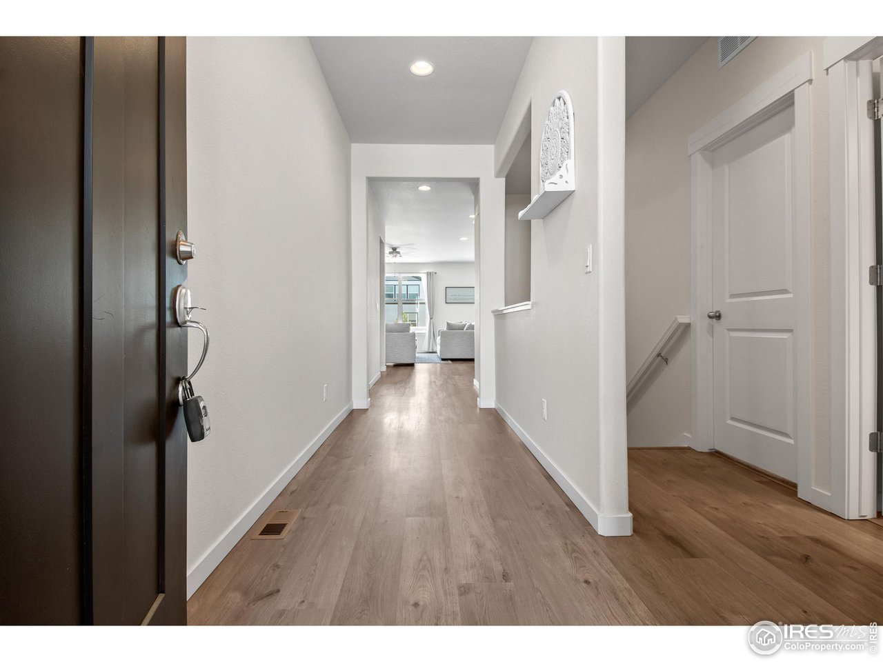2107 Setting Sun Drive Windsor, CO 80550 - Photo 14 of 40 a view of hallway with wooden floor
