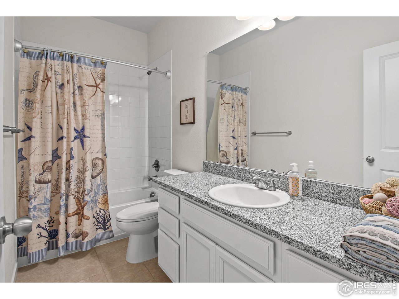 2107 Setting Sun Drive Windsor, CO 80550 - Photo 17 of 40 a bathroom with a granite countertop sink and a mirror