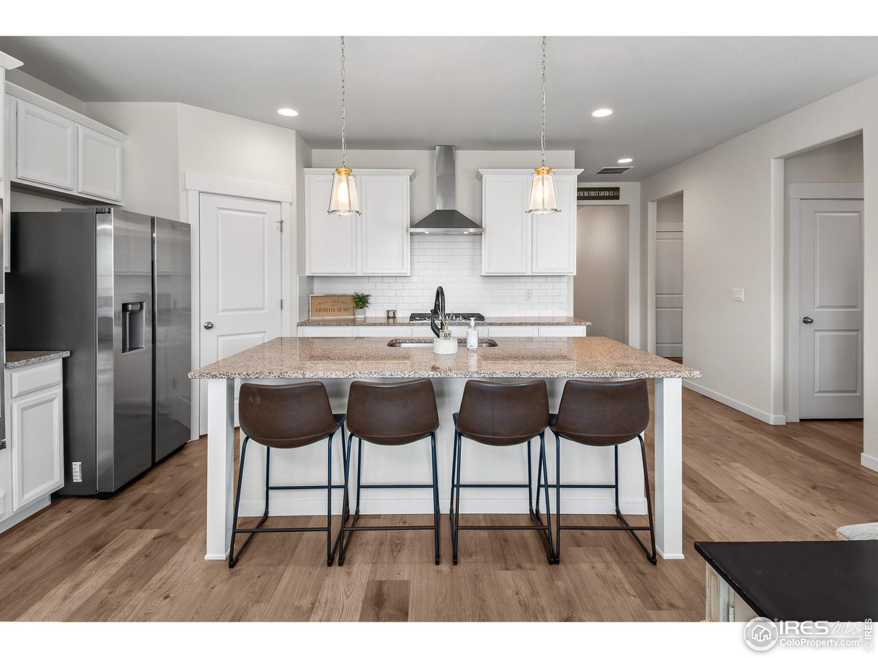 2107 Setting Sun Drive Windsor, CO 80550 - Photo 21 of 40 a kitchen with a sink and chairs