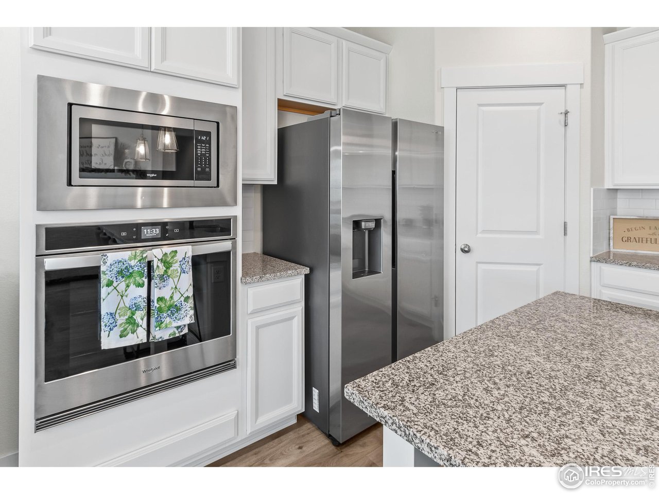 2107 Setting Sun Drive Windsor, CO 80550 - Photo 23 of 40 a kitchen with stainless steel appliances kitchen island granite countertop a refrigerator and microwave