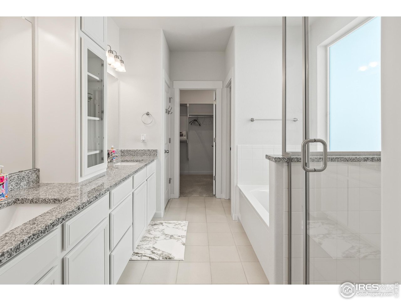 2107 Setting Sun Drive Windsor, CO 80550 - Photo 32 of 40 a bathroom with a granite countertop sink mirror and a
