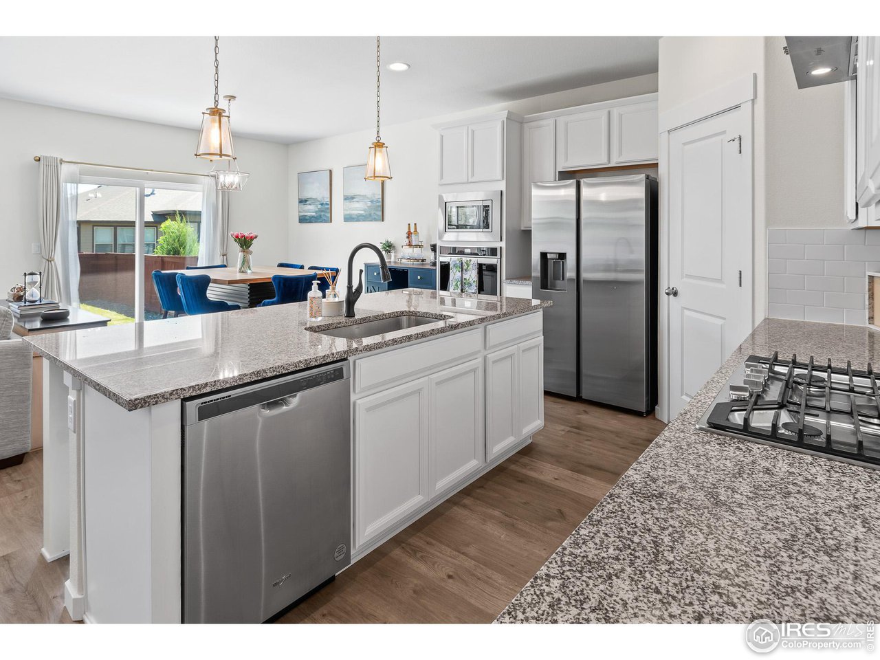 2107 Setting Sun Drive Windsor, CO 80550 - Photo 5 of 40 a kitchen with stainless steel appliances granite countertop a sink stove and refrigerator