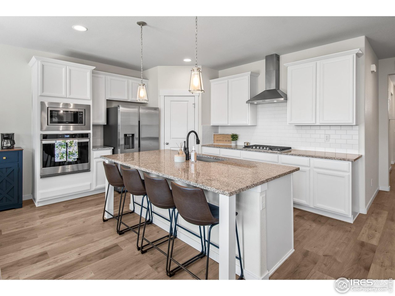 2107 Setting Sun Drive Windsor, CO 80550 - Photo 6 of 40 a kitchen with stainless steel appliances kitchen island granite countertop a sink and cabinets