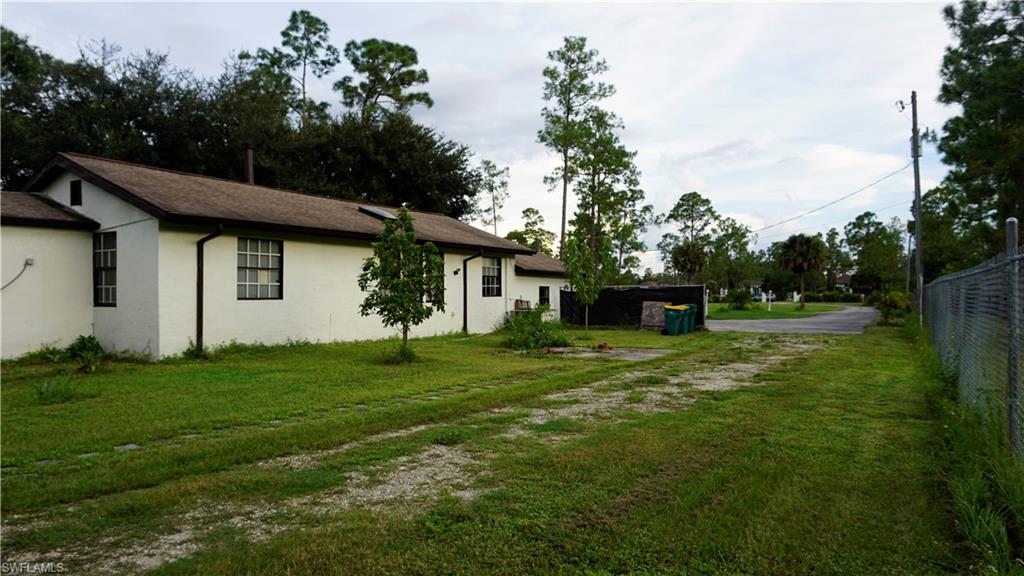 2407 Randall Boulevard Naples, FL 34120 - Photo 13 of 46 a backyard of a house with plants and large trees