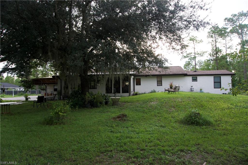 2407 Randall Boulevard Naples, FL 34120 - Photo 19 of 46 a front view of house with a garden and patio