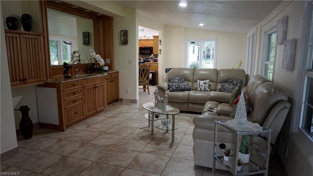 2407 Randall Boulevard Naples, FL 34120 - Photo 25 of 46 a living room with furniture and a large mirror
