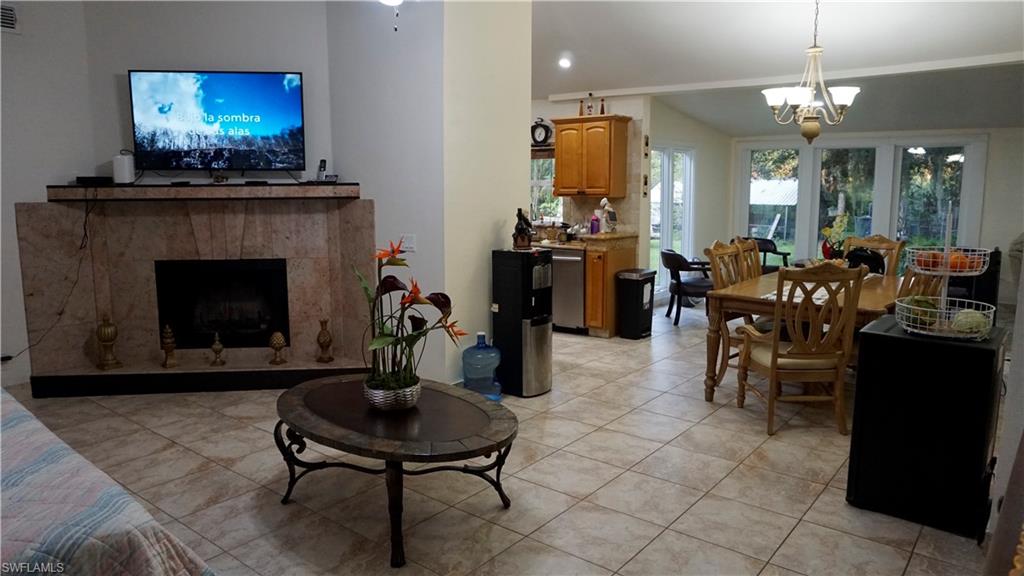 2407 Randall Boulevard Naples, FL 34120 - Photo 29 of 46 a living room with furniture a chandelier and a fireplace