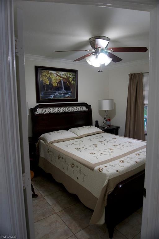 2407 Randall Boulevard Naples, FL 34120 - Photo 34 of 46 a bedroom with a bed and a chandelier