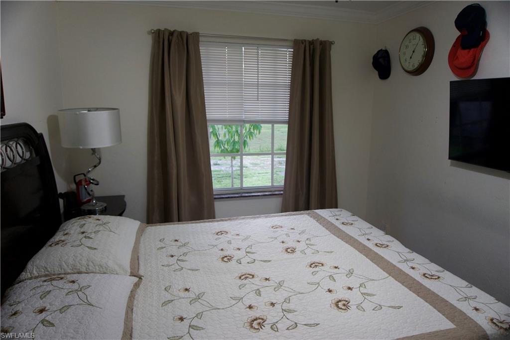 2407 Randall Boulevard Naples, FL 34120 - Photo 35 of 46 a bedroom with a bed and a window