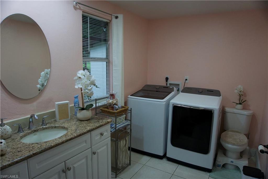 2407 Randall Boulevard Naples, FL 34120 - Photo 39 of 46 a bathroom with a granite countertop toilet sink and mirror