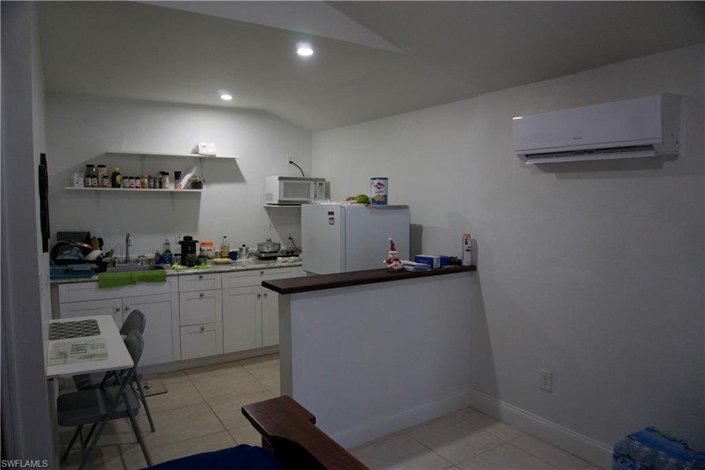 2407 Randall Boulevard Naples, FL 34120 - Photo 41 of 46 a kitchen with granite countertop a sink cabinets and stove top oven
