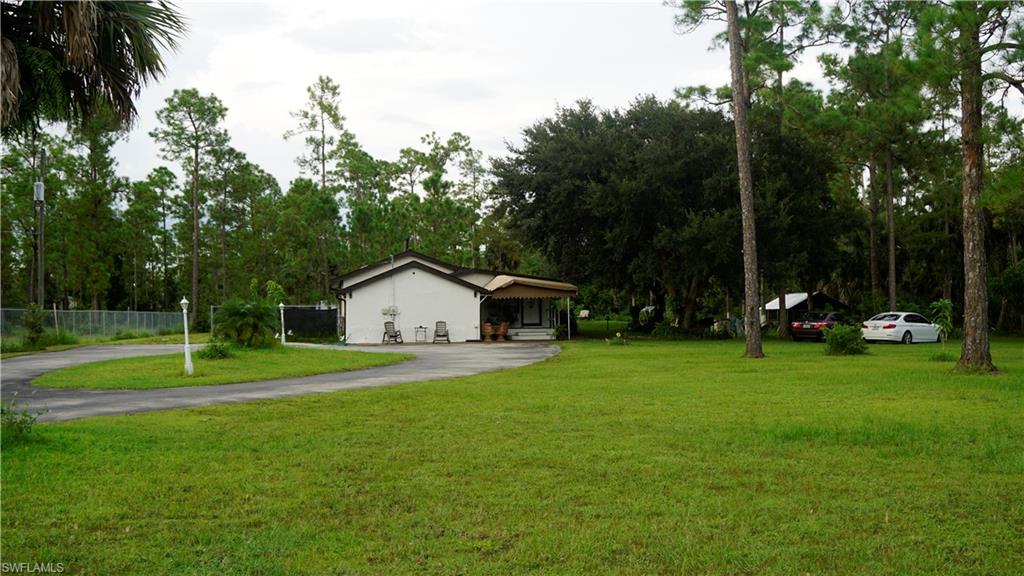 2407 Randall Boulevard Naples, FL 34120 - Photo 6 of 46 a view of a house with a big yard and palm trees