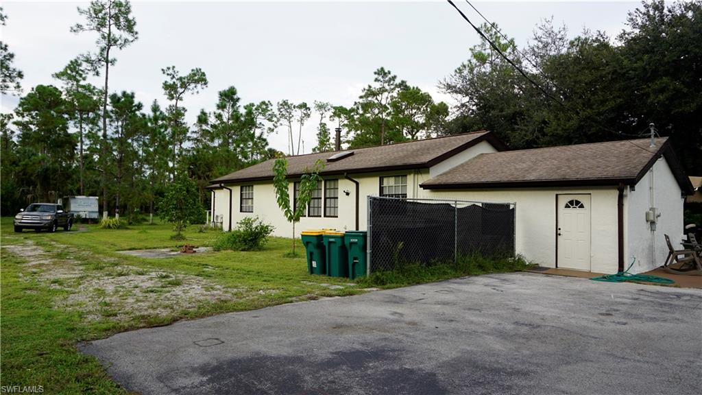 2407 Randall Boulevard Naples, FL 34120 - Photo 10 of 46 a front view of a house with a yard and garage