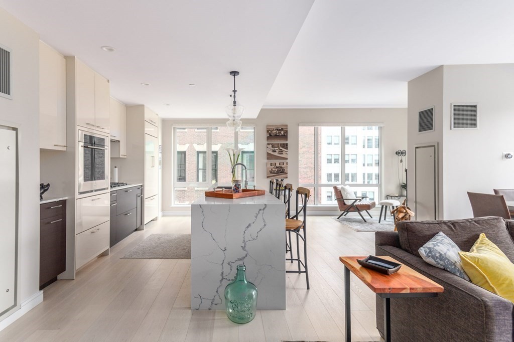 110 Broad Street, Unit 501 Boston, MA 02110 - Photo 28 of 41 a living room with furniture a large window and stainless steel appliances
