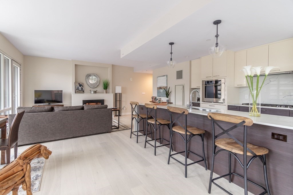 110 Broad Street, Unit 501 Boston, MA 02110 - Photo 30 of 41 a living room with furniture a fireplace and a chandelier