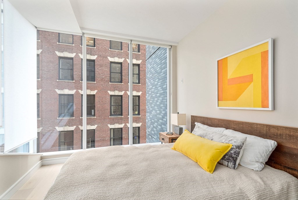 110 Broad Street, Unit 501 Boston, MA 02110 - Photo 5 of 41 a bedroom with a bed and a night stand