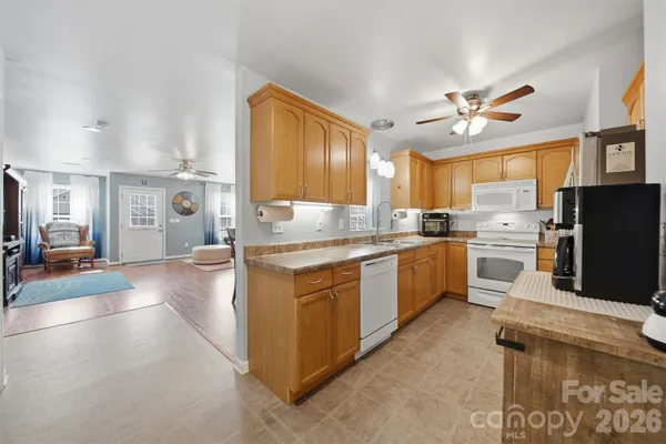 a kitchen with a refrigerator a sink dishwasher stove and oven