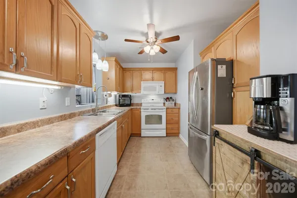 a kitchen with cabinets a center island stainless steel appliances and a window