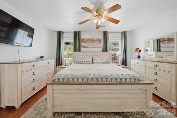 a bedroom with a bed a window and a flat screen television