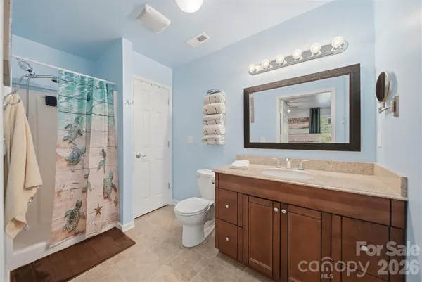 a bathroom with a toilet a sink and a large mirror