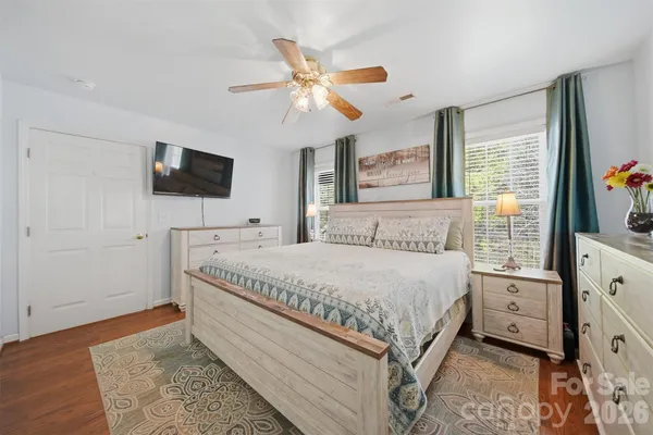 a spacious bedroom with a bed and a flat screen tv