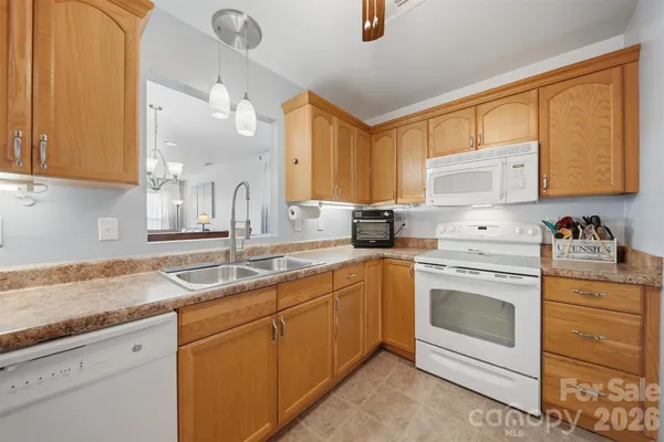 a kitchen with granite countertop a sink stainless steel appliances and cabinets
