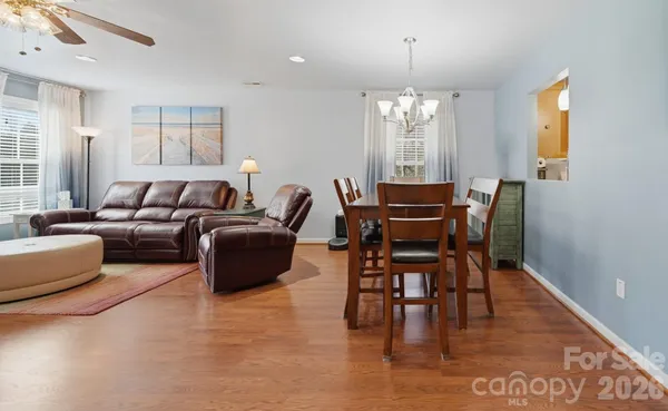 a living room with furniture dining table and a chandelier