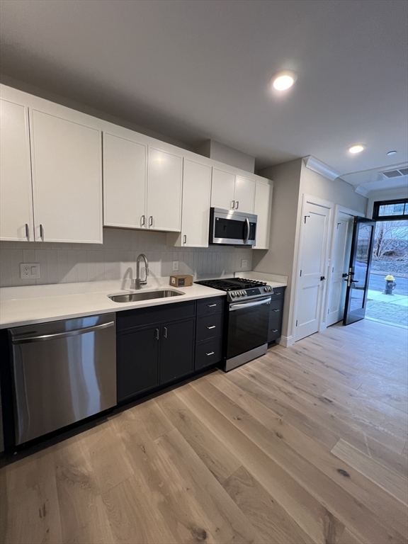 a kitchen with stainless steel appliances granite countertop a refrigerator a sink a stove and cabinets