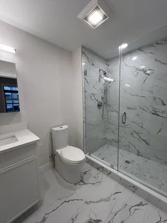 a bathroom with a shower toilet and sink