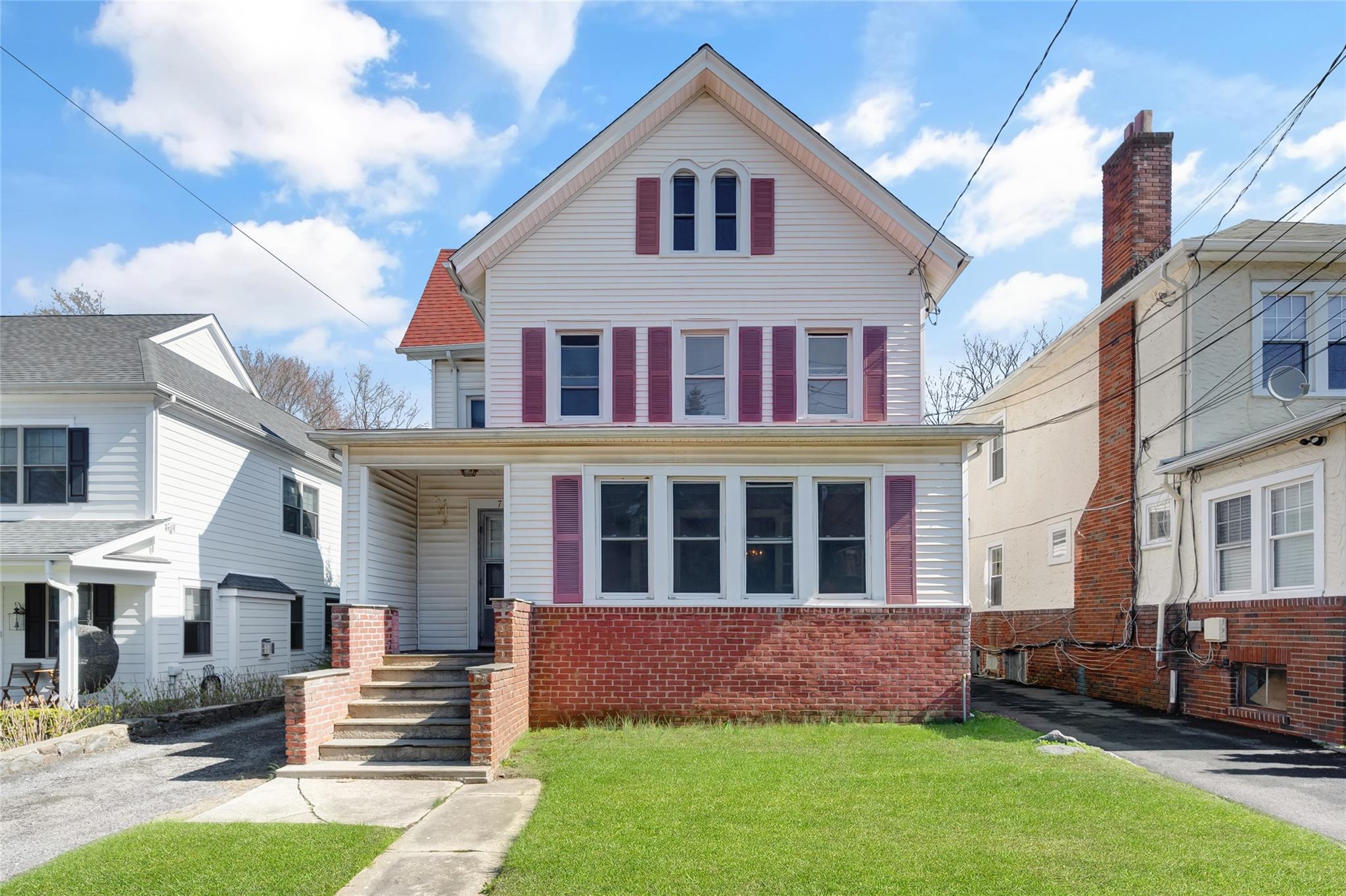 Traditional style home with brick siding and a front lawn