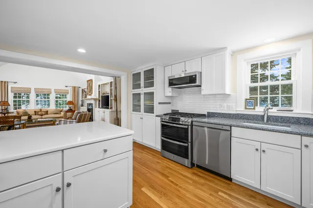 a kitchen with stainless steel appliances granite countertop a stove a sink and a microwave