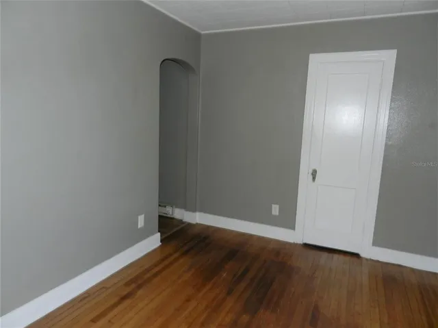 an empty room with wooden floor and closet