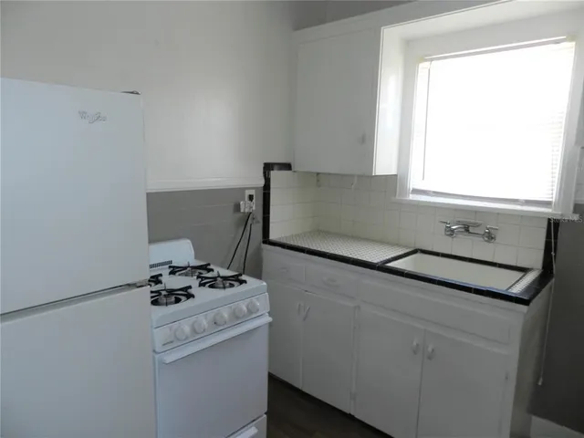 a kitchen with appliances cabinets and a window