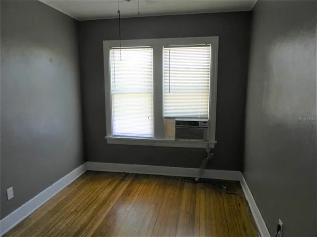 a view of small space with wooden floor and a window