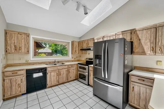 a kitchen with stainless steel appliances granite countertop a refrigerator and a stove top oven