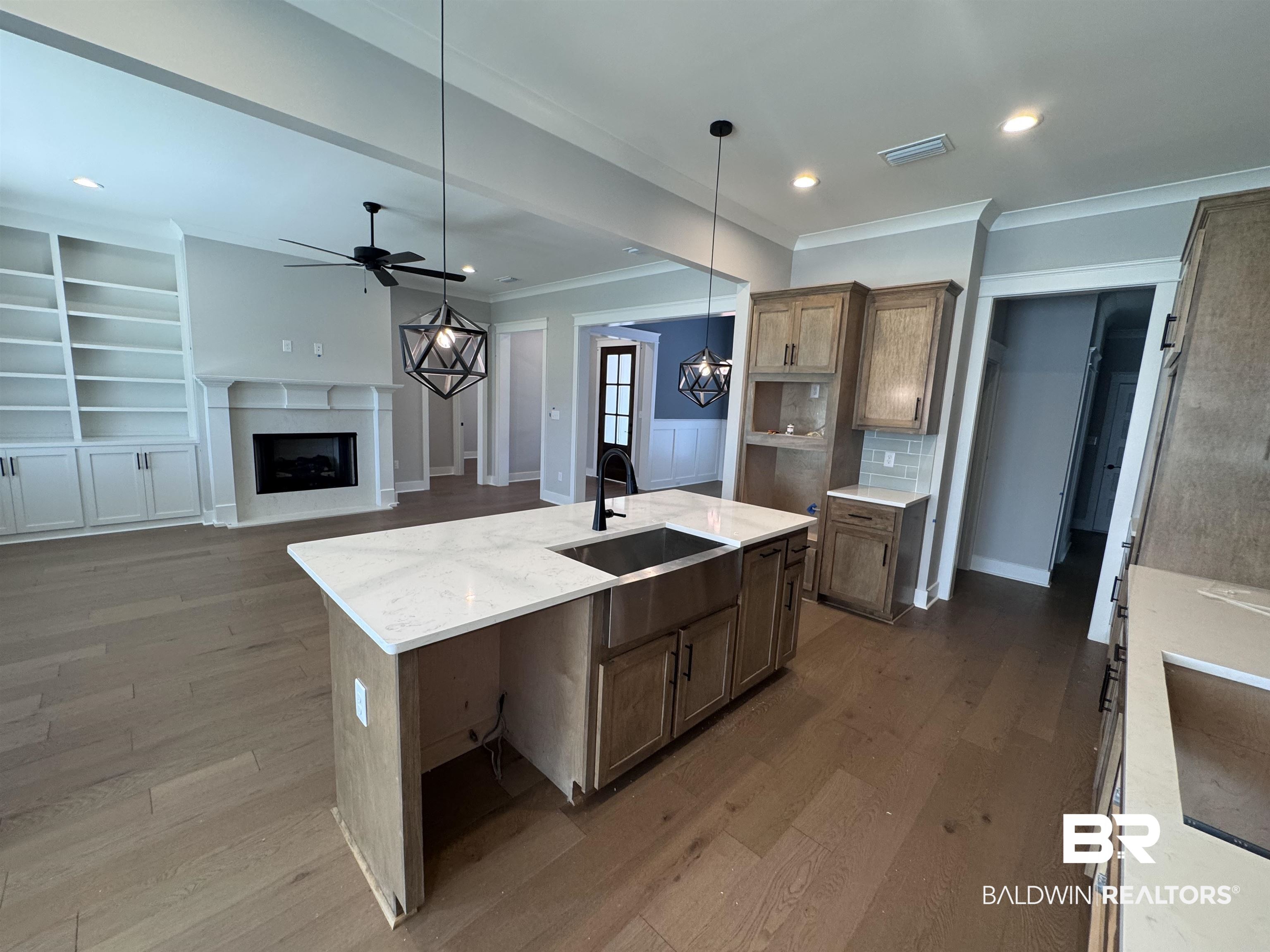 27371 Patch Pl Loop Daphne, AL 36526 - Photo 23 of 63 Kitchen featuring built in features, a center island with sink, dark wood-style flooring, a fireplace, and crown molding