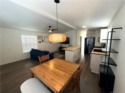 a living room with furniture a flat screen tv and kitchen view
