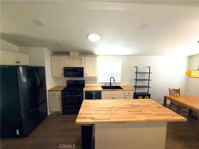 a large kitchen with stainless steel appliances kitchen island a cabinets and wooden floor